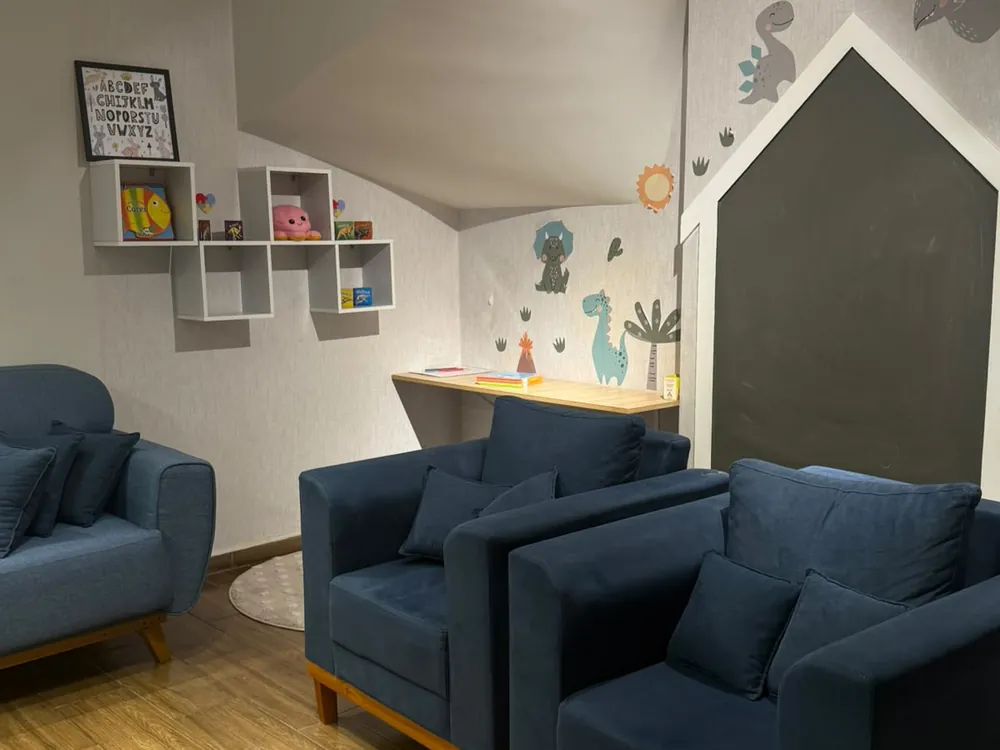 Recepção do consultório, com poltronas e cantinho infantil